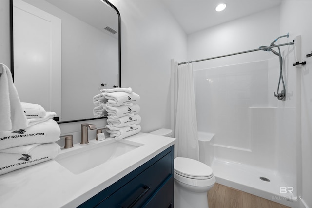 bathroom featuring toilet, vanity, curtained shower, and visible vents