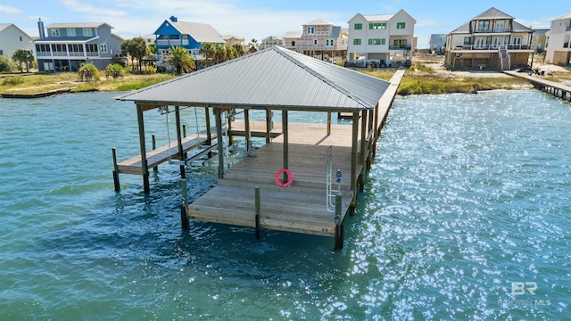 view of dock with a water view, a residential view, and boat lift