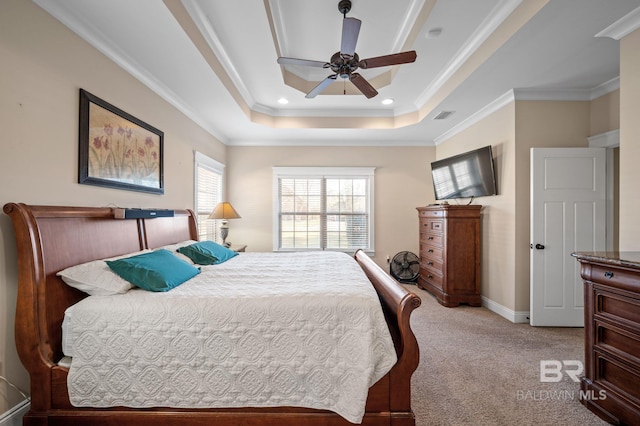 bedroom with baseboards, visible vents, light colored carpet, a tray ceiling, and crown molding