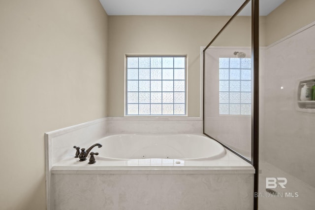 bathroom featuring a jetted tub and walk in shower