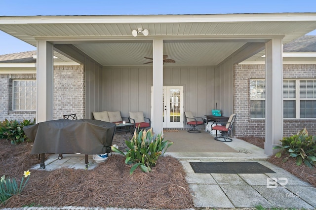 doorway to property with a patio area, a ceiling fan, and brick siding