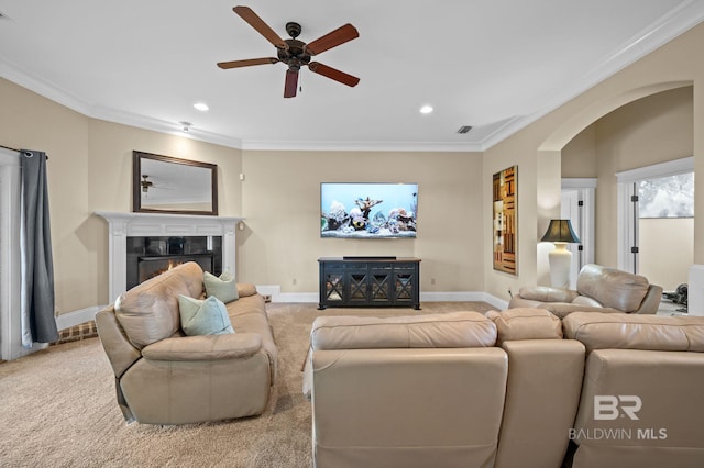 living room featuring ornamental molding, carpet flooring, and a glass covered fireplace