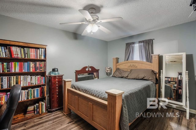 bedroom with ceiling fan, hardwood / wood-style floors, and a textured ceiling