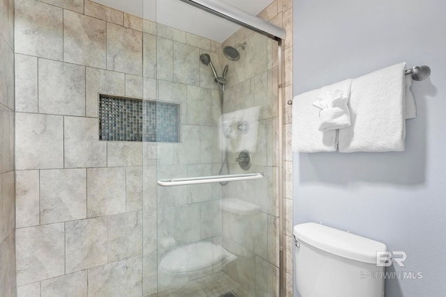 bathroom with toilet and a shower with shower door