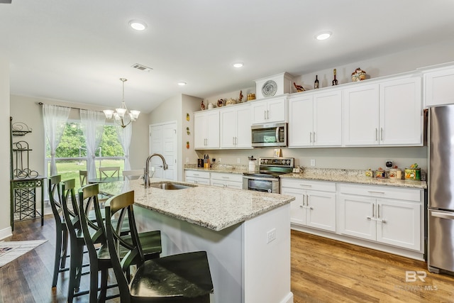 kitchen featuring appliances with stainless steel finishes, an island with sink, white cabinetry, and sink