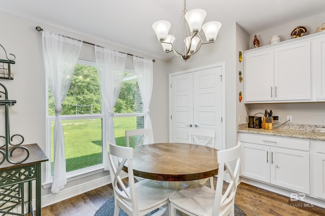 dining area with a notable chandelier and dark hardwood / wood-style floors