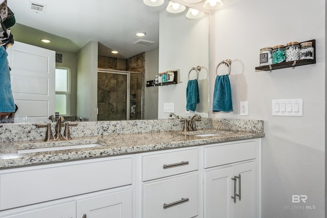 bathroom with vanity and a shower with shower door