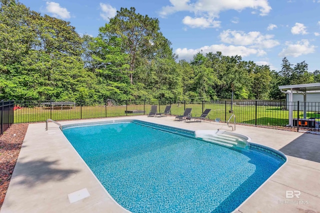 view of swimming pool featuring a lawn and a patio