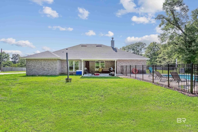 back of property featuring a yard, a fenced in pool, and a patio area