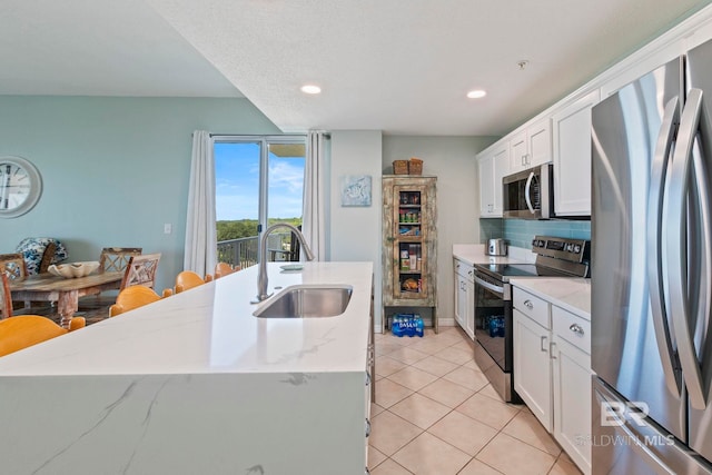 kitchen with sink, decorative backsplash, white cabinetry, and appliances with stainless steel finishes