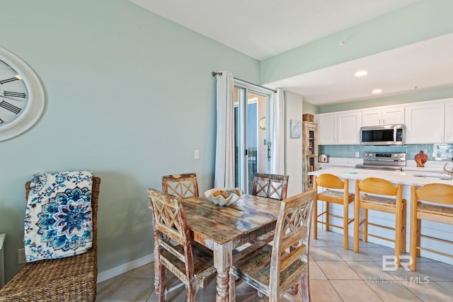 dining area featuring sink and light tile patterned floors