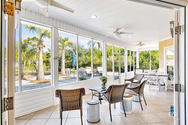 sunroom / solarium featuring a healthy amount of sunlight and ceiling fan