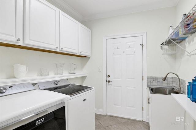 clothes washing area with sink, cabinets, light tile patterned floors, ornamental molding, and independent washer and dryer