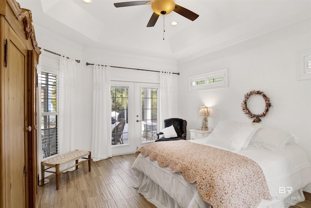 bedroom featuring multiple windows, access to outside, french doors, and a tray ceiling