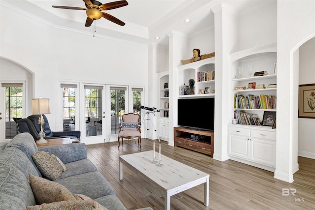 living room featuring french doors, built in features, ceiling fan, and hardwood / wood-style floors