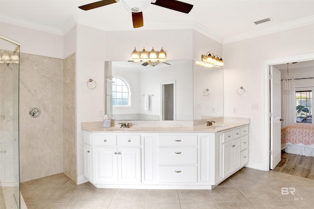 bathroom with tile patterned flooring, crown molding, a tile shower, and vanity