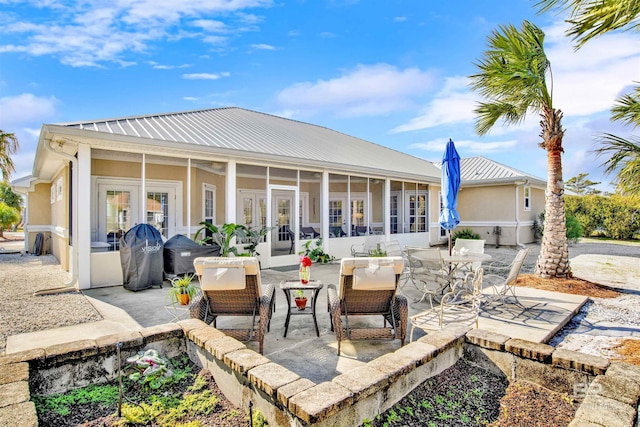 view of patio featuring french doors, area for grilling, and a sunroom