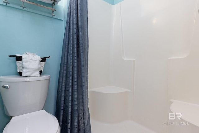 bathroom featuring curtained shower and toilet