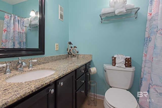 bathroom featuring tile patterned flooring, vanity, and toilet