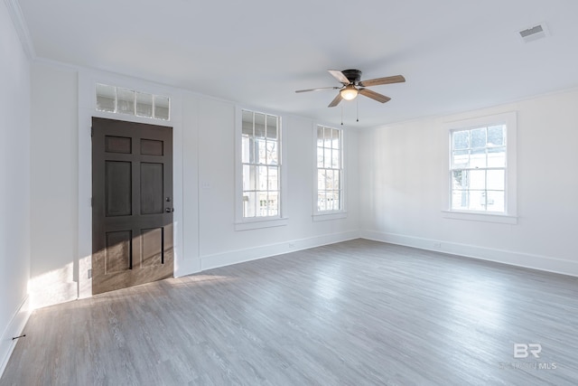 interior space with dark wood-type flooring, ceiling fan, and ornamental molding