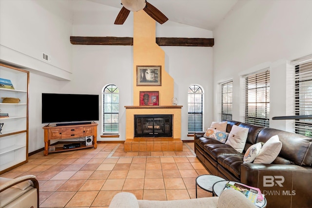 living room with high vaulted ceiling, ceiling fan, light tile patterned flooring, and a healthy amount of sunlight