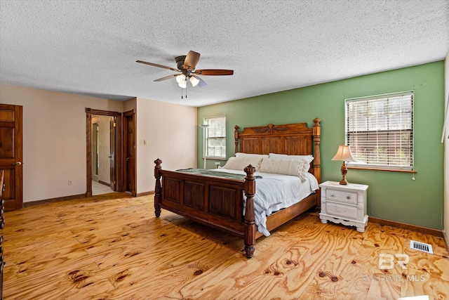 bedroom with ceiling fan, a textured ceiling, and light wood-type flooring