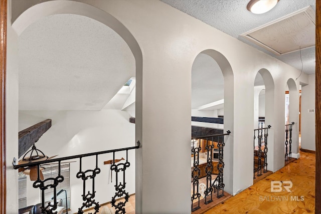 hallway with a textured ceiling and wood-type flooring