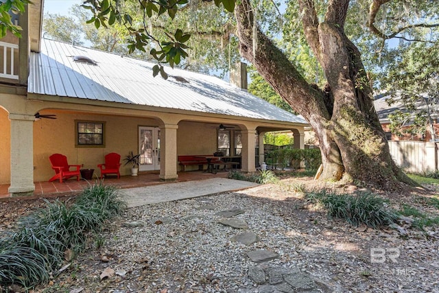 rear view of property featuring ceiling fan and a patio