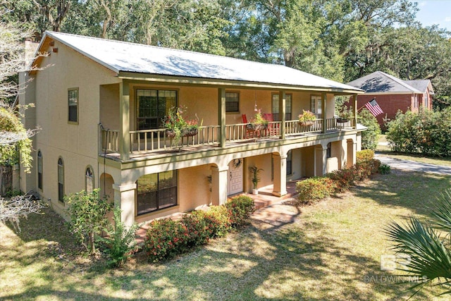 view of front of property with a balcony and a front lawn