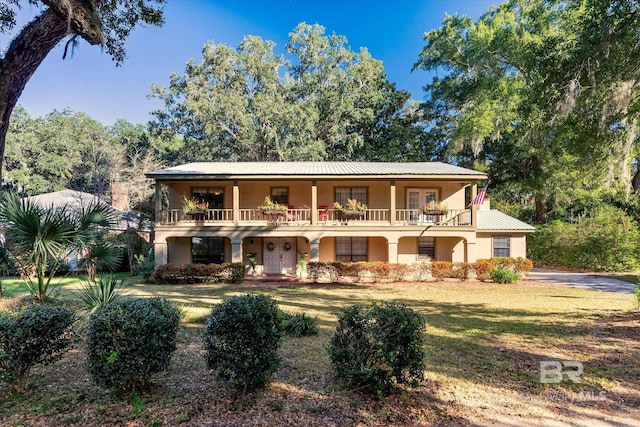 view of front facade featuring a balcony and a front lawn