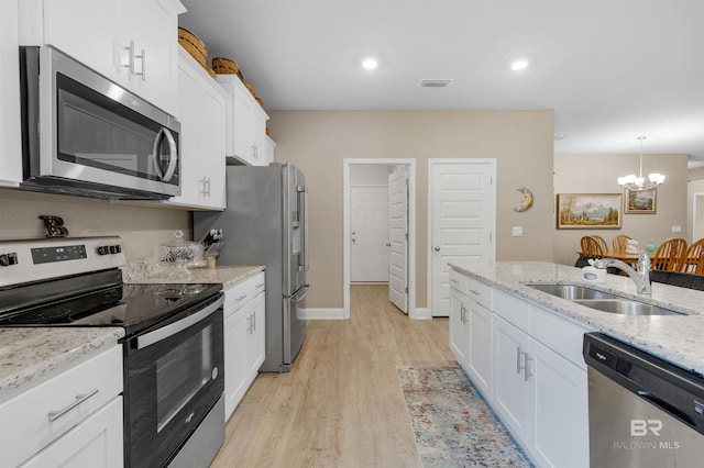 kitchen featuring sink, light stone counters, light wood-type flooring, white cabinetry, and stainless steel appliances