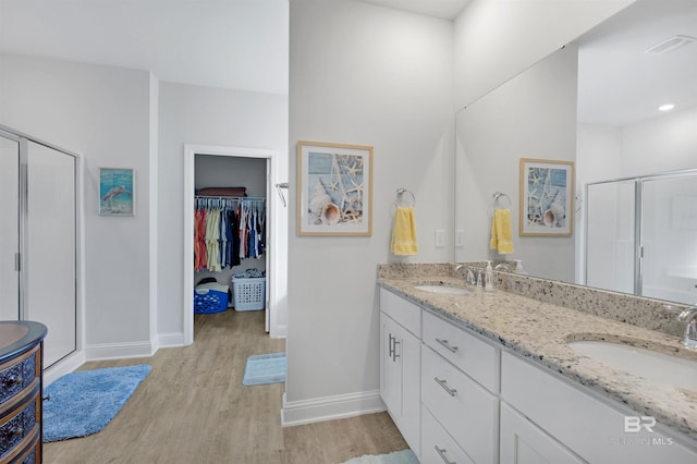 bathroom featuring hardwood / wood-style flooring, an enclosed shower, and vanity