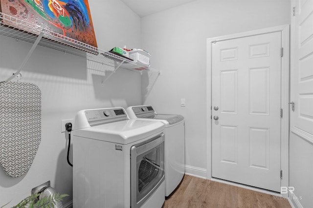 laundry room with light hardwood / wood-style floors and separate washer and dryer