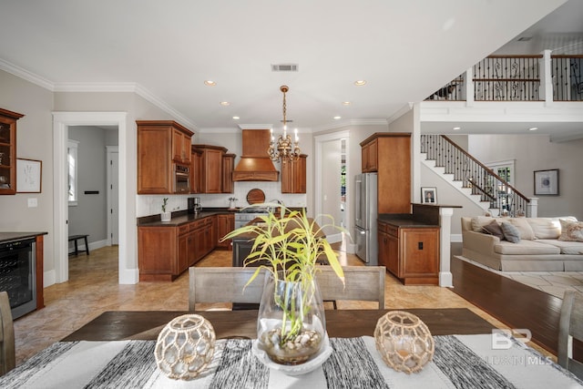 dining area featuring ornamental molding, wine cooler, and a chandelier