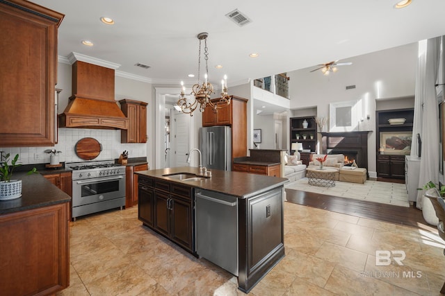 kitchen with an island with sink, light hardwood / wood-style flooring, high end appliances, sink, and crown molding