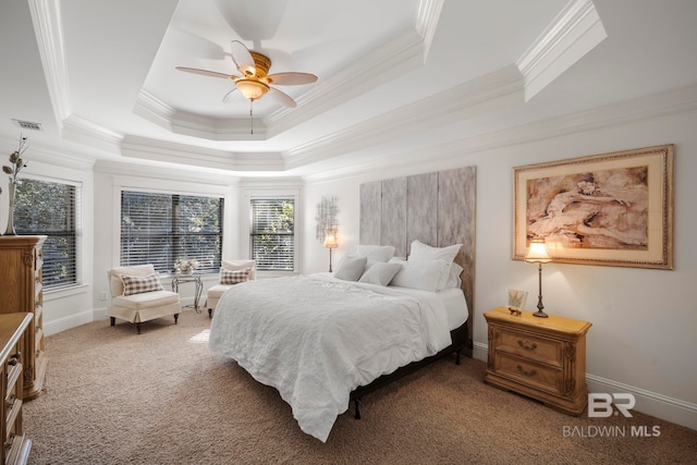 bedroom with ceiling fan, carpet flooring, ornamental molding, and a tray ceiling