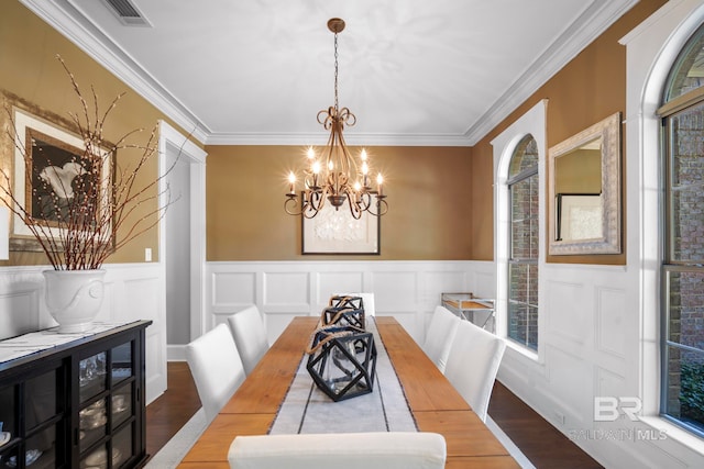 dining area featuring ornamental molding, a notable chandelier, and wood-type flooring