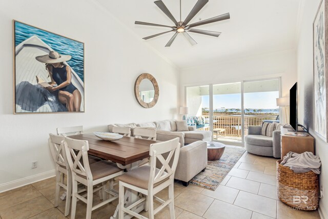 tiled dining space with ceiling fan and lofted ceiling