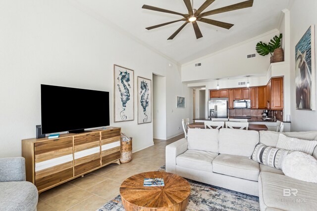 tiled living room with ceiling fan and high vaulted ceiling