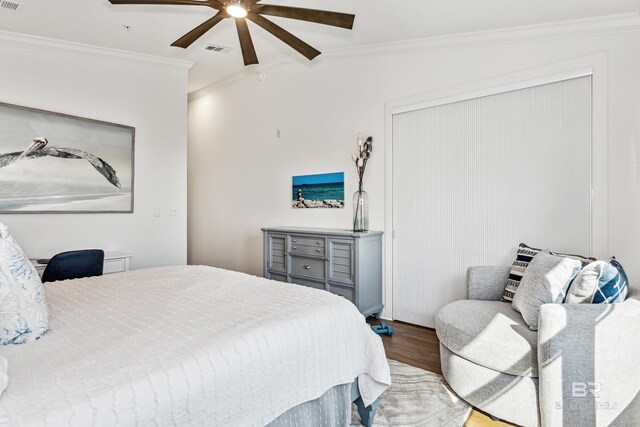 bedroom featuring lofted ceiling, crown molding, hardwood / wood-style flooring, ceiling fan, and a closet