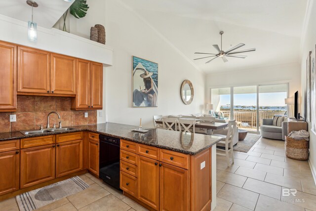 kitchen featuring dishwasher, sink, hanging light fixtures, kitchen peninsula, and dark stone counters