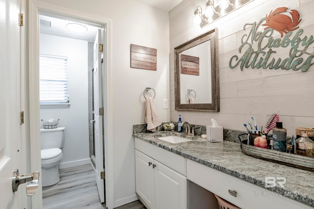 bathroom with vanity, hardwood / wood-style flooring, and toilet