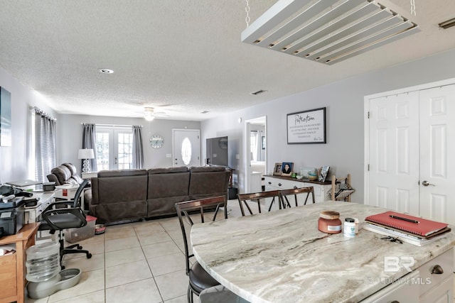 dining room featuring french doors, a textured ceiling, ceiling fan, and light tile patterned floors