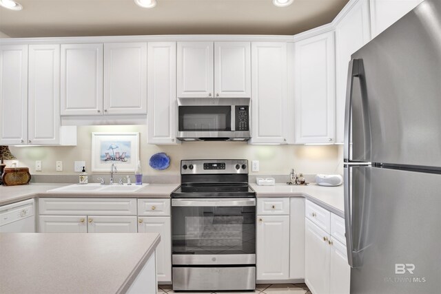 kitchen with appliances with stainless steel finishes, white cabinetry, and sink