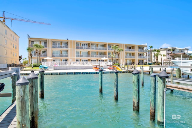 dock area with a balcony and a water view