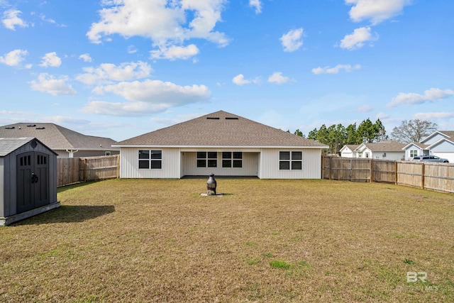 rear view of property featuring a shed and a lawn