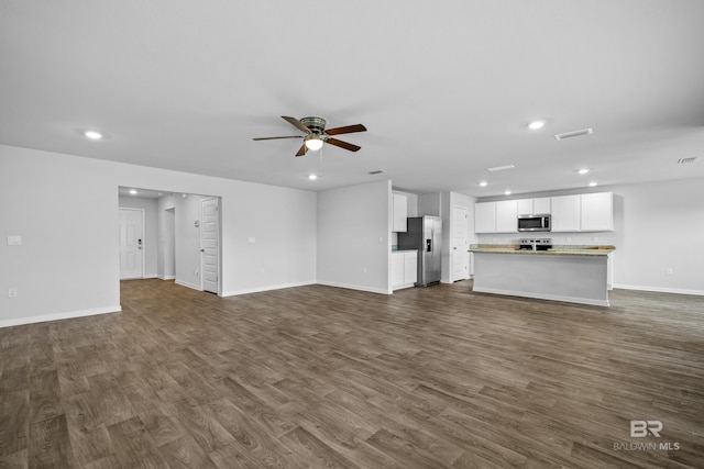 unfurnished living room featuring ceiling fan and dark hardwood / wood-style flooring