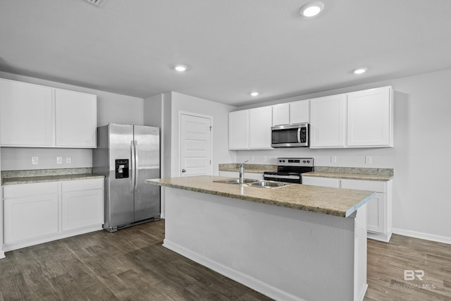 kitchen with an island with sink, white cabinetry, sink, stainless steel appliances, and dark wood-type flooring