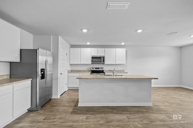 kitchen with white cabinetry, sink, a kitchen island with sink, stainless steel appliances, and light wood-type flooring