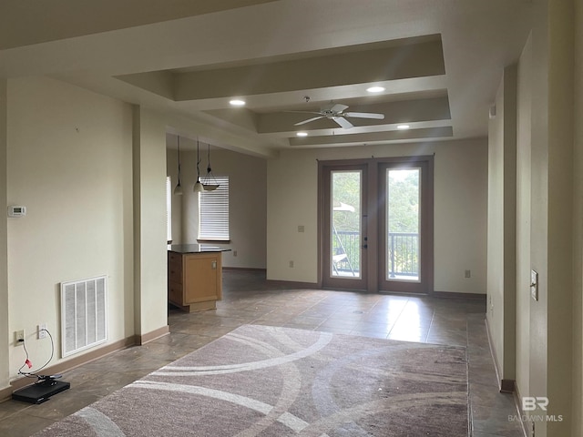 living area featuring a ceiling fan, baseboards, visible vents, a tray ceiling, and recessed lighting